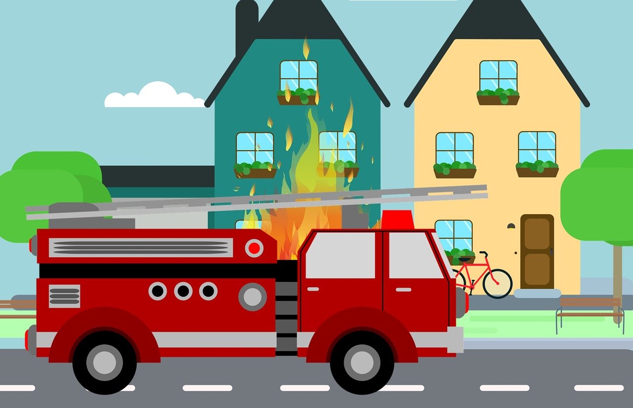Un camion de pompier devant une maison en feu